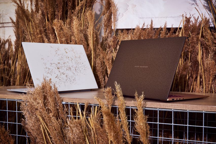 Two of ASUS's Ceraluminum Signature Edition Zenbook laptops surrounded by wheat