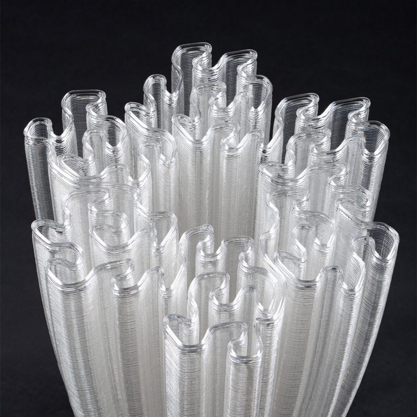 a photograph of the top of a plastic lamp in the shape of intricate patterns, in tones of white against a black backdrop
