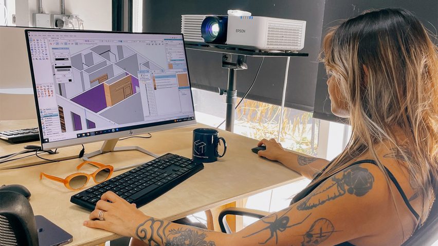 a photograph of a person sat at a desk using a computer