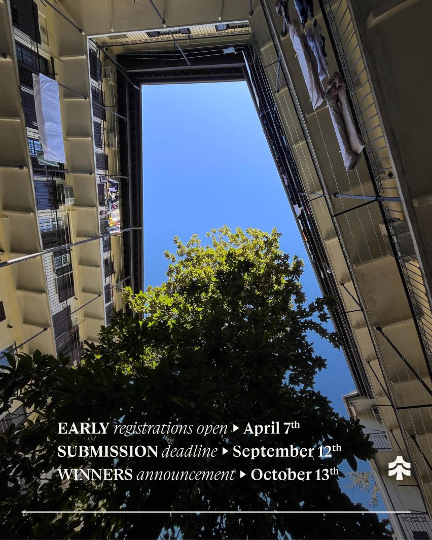 a photograph from below of an apartment building. There is a blue sky above and a green tree. White text is overlaid on the photograp.