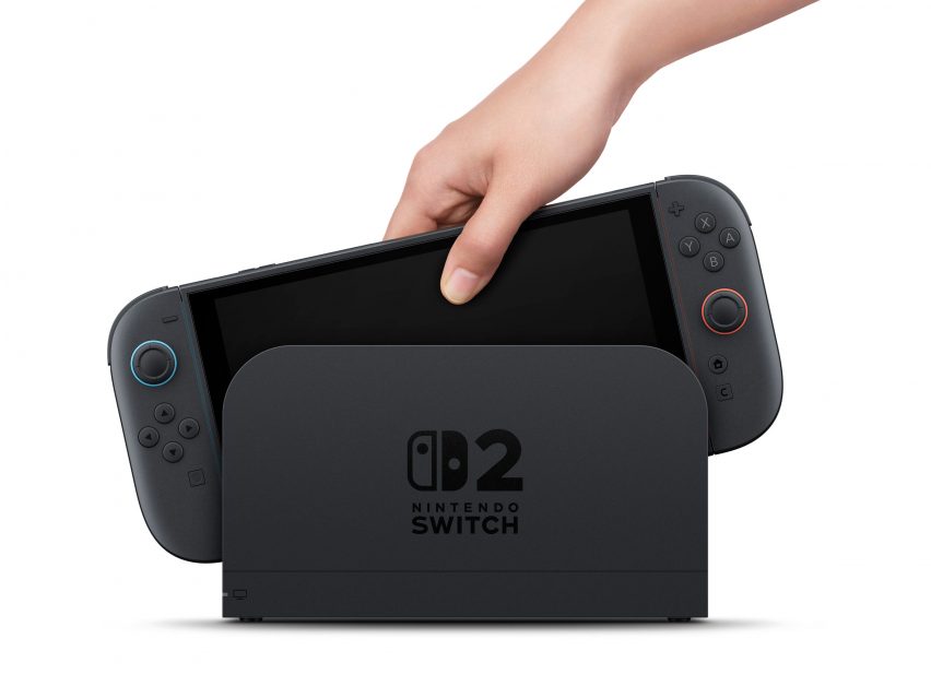 Image of a person's hand sliding a Nintendo Switch 2 into the dock