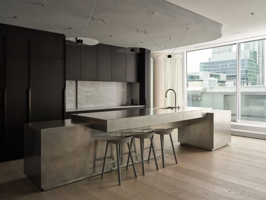 A monumental kitchen island comprising stacked tin-wrapped volumes