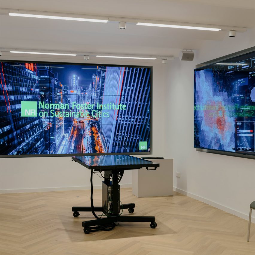 a photograph of a lecture room in a university two blue screens on each of its walls