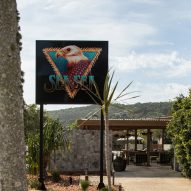 Motel driveway with cactus, palms and large sign saying Sea Sea