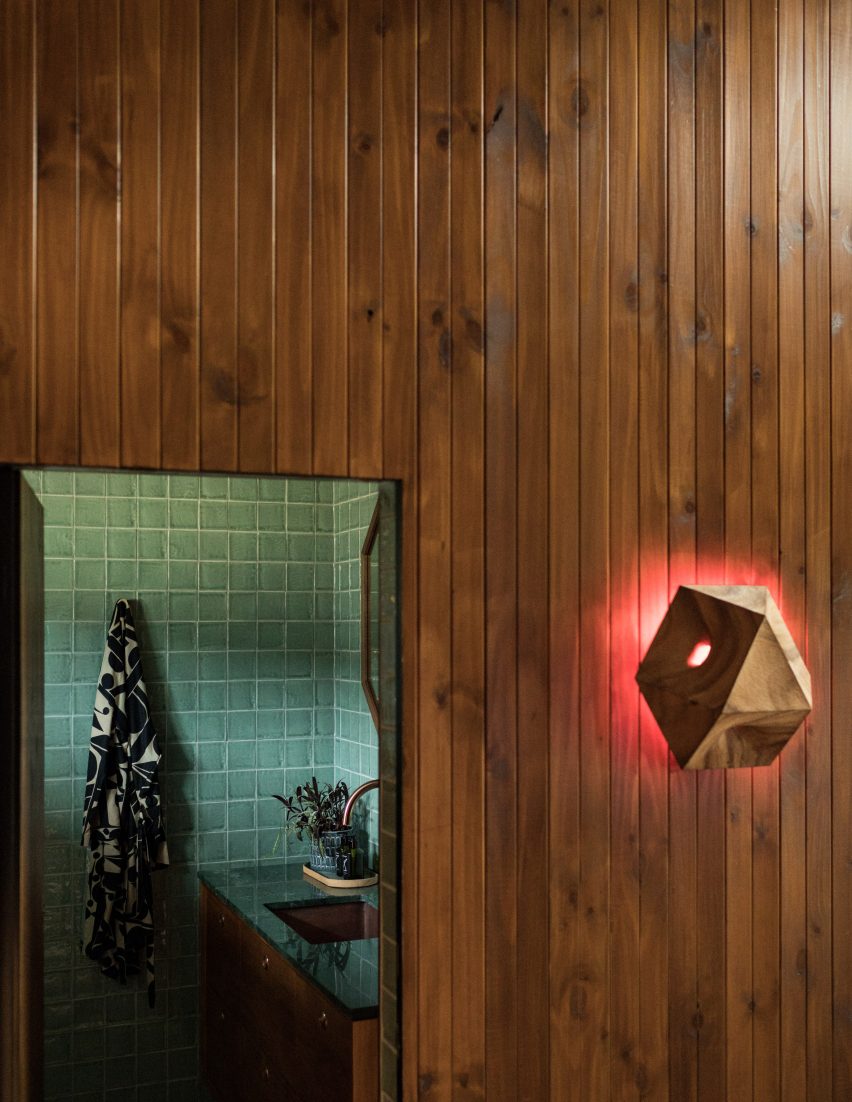 Carved wooden light emitting red glow hung on a wood-panelled wall