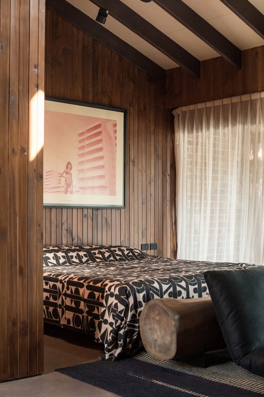 Bedroom with patterned throw on bed and floor sofa made from cushions