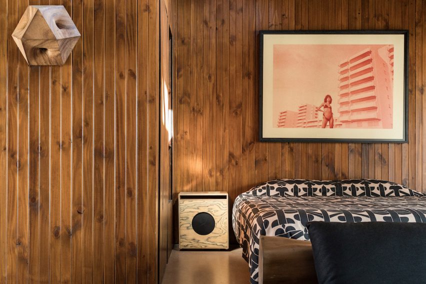 Bedroom with wood panelling and side table speaker