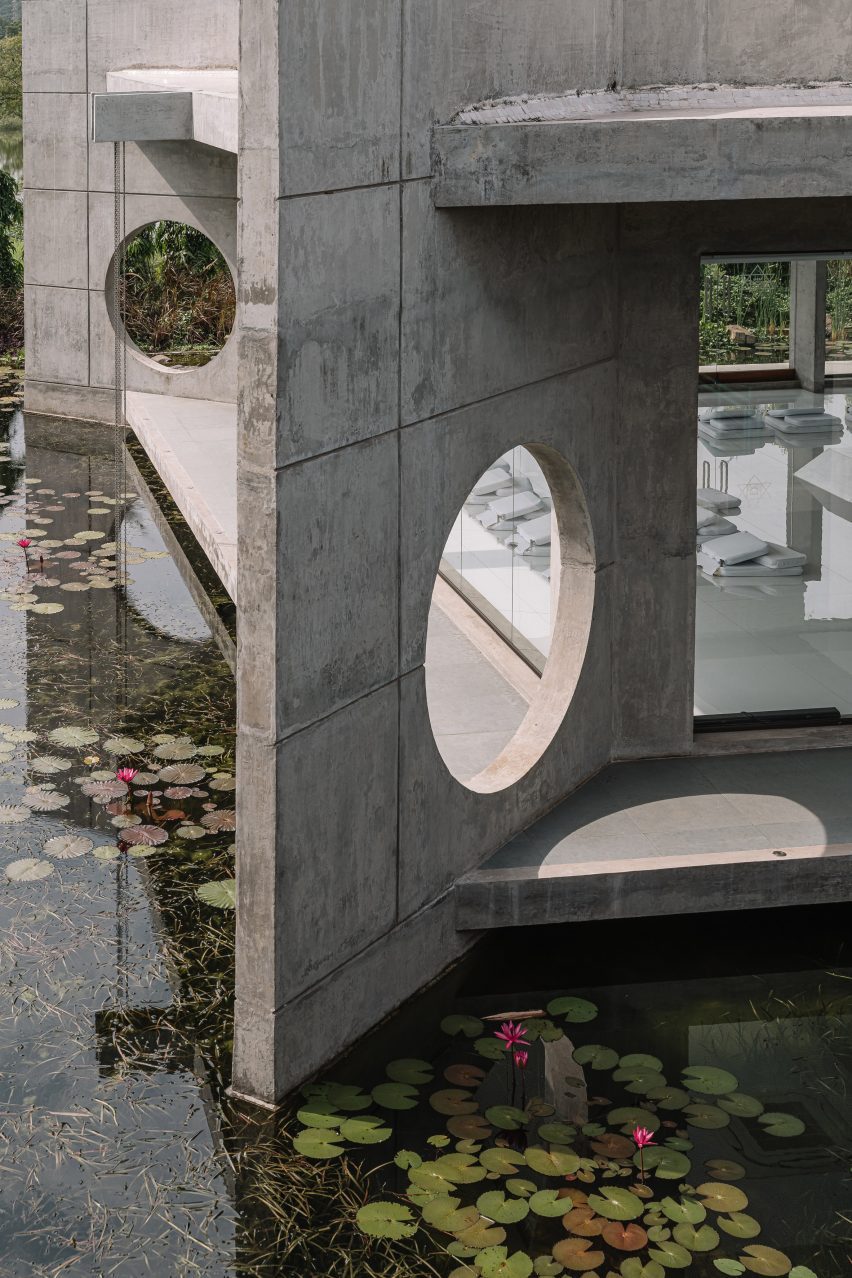 Sculptural concrete building in India surrounded by ponds
