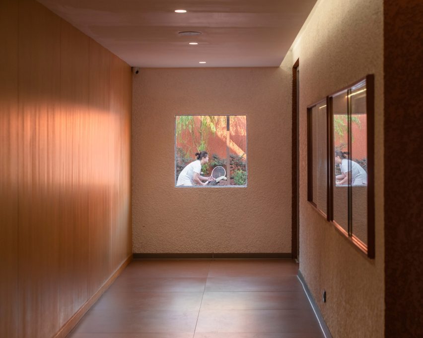 Corridor with window at end showing onto tennis court