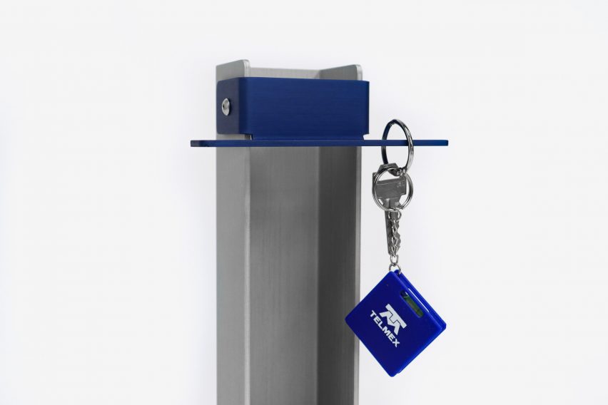 a photograph of a silver and blue rectangular object. There is a key hanging from it.