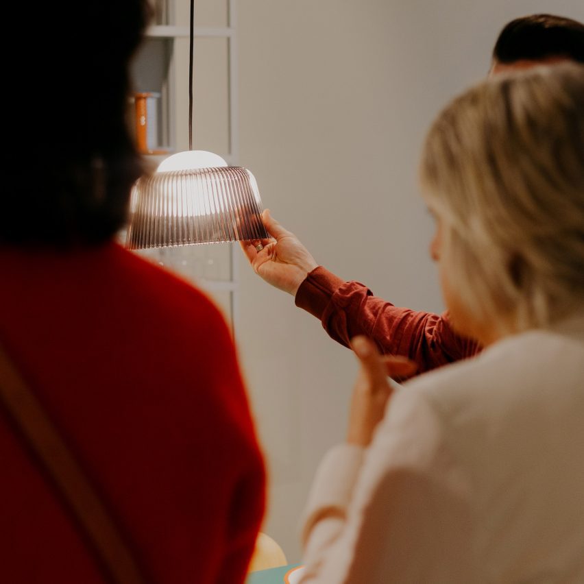 Photo of people looking at and holding a light by Hay