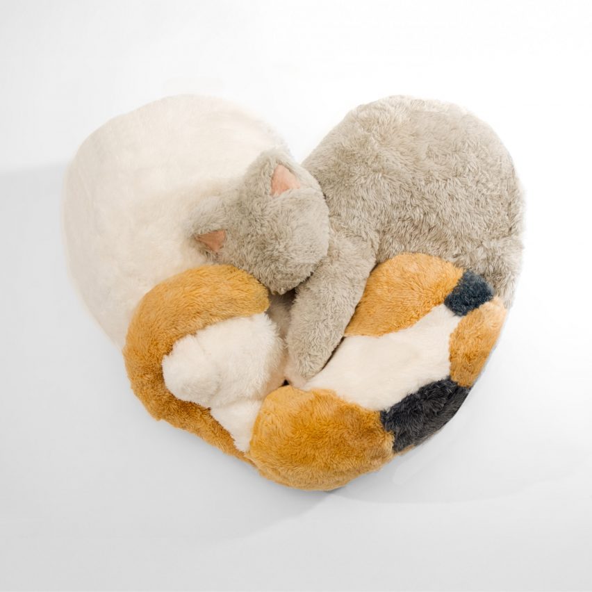 a photograph of a cushion in the shape if a heart formed of cat soft toys