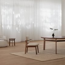 Photo of wooden chair and tables on a beige rug