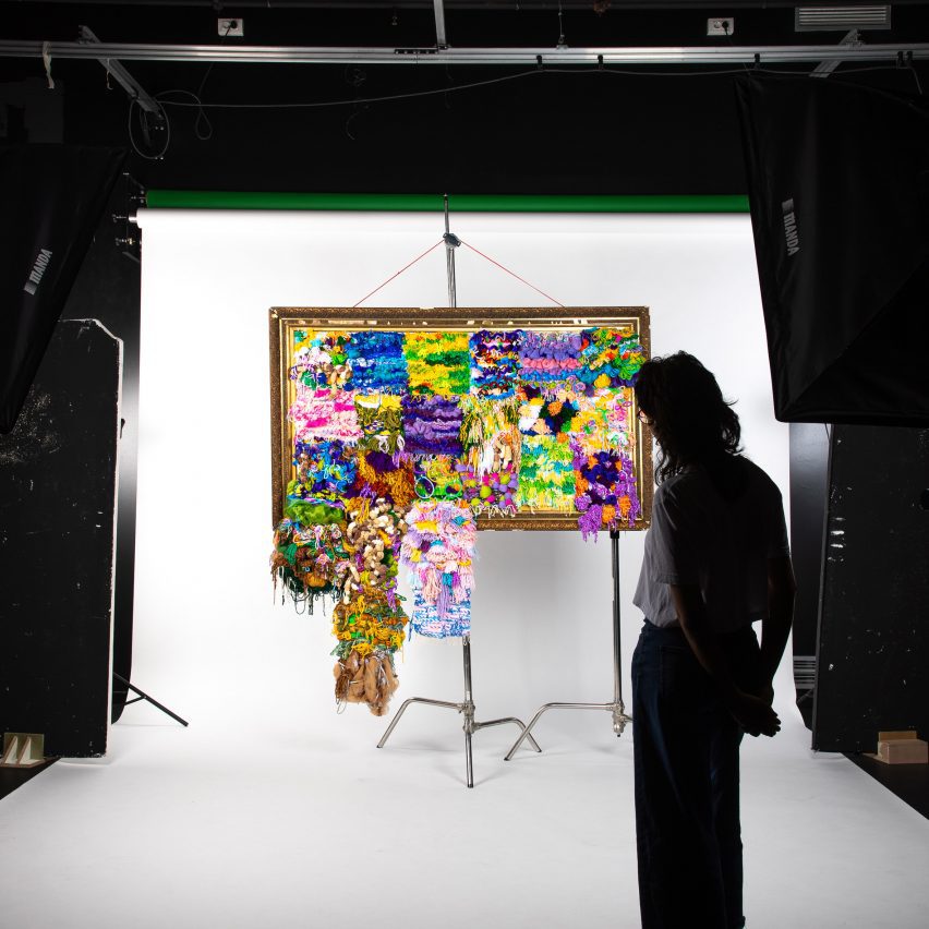 Photo of person stood in front of colourful Unwoven Memories tapestry