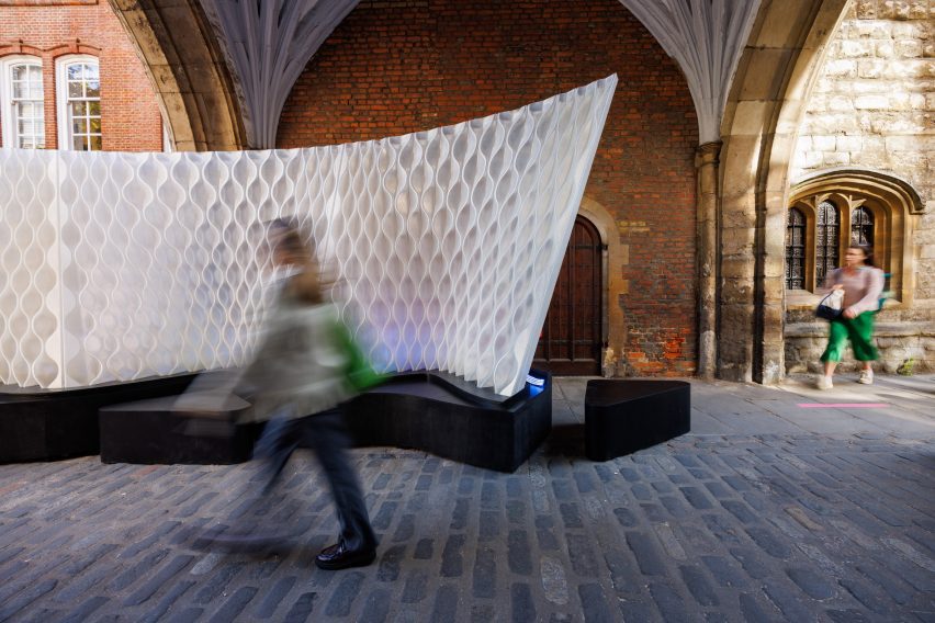 Person walking through Arthur Mamou-Mani's Harmonic Tides installation at St John's Gate archway