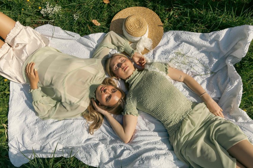 a photograph of two people lying down on a blanket outside