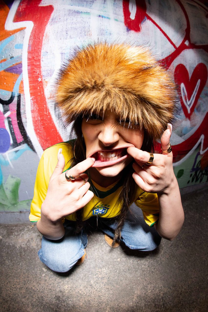 a photograph of a person facing the camera with a brown fluffy hat on
