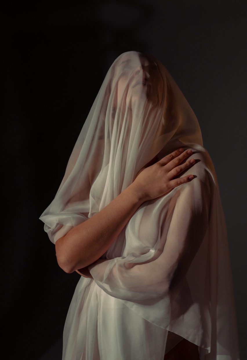 a photograph of a person draped in beige fabric