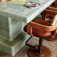 Chair tucked underneath pale green tiled bar top