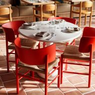 Red chairs over thick terracotta floors in restaurant by Luchetti Krelle