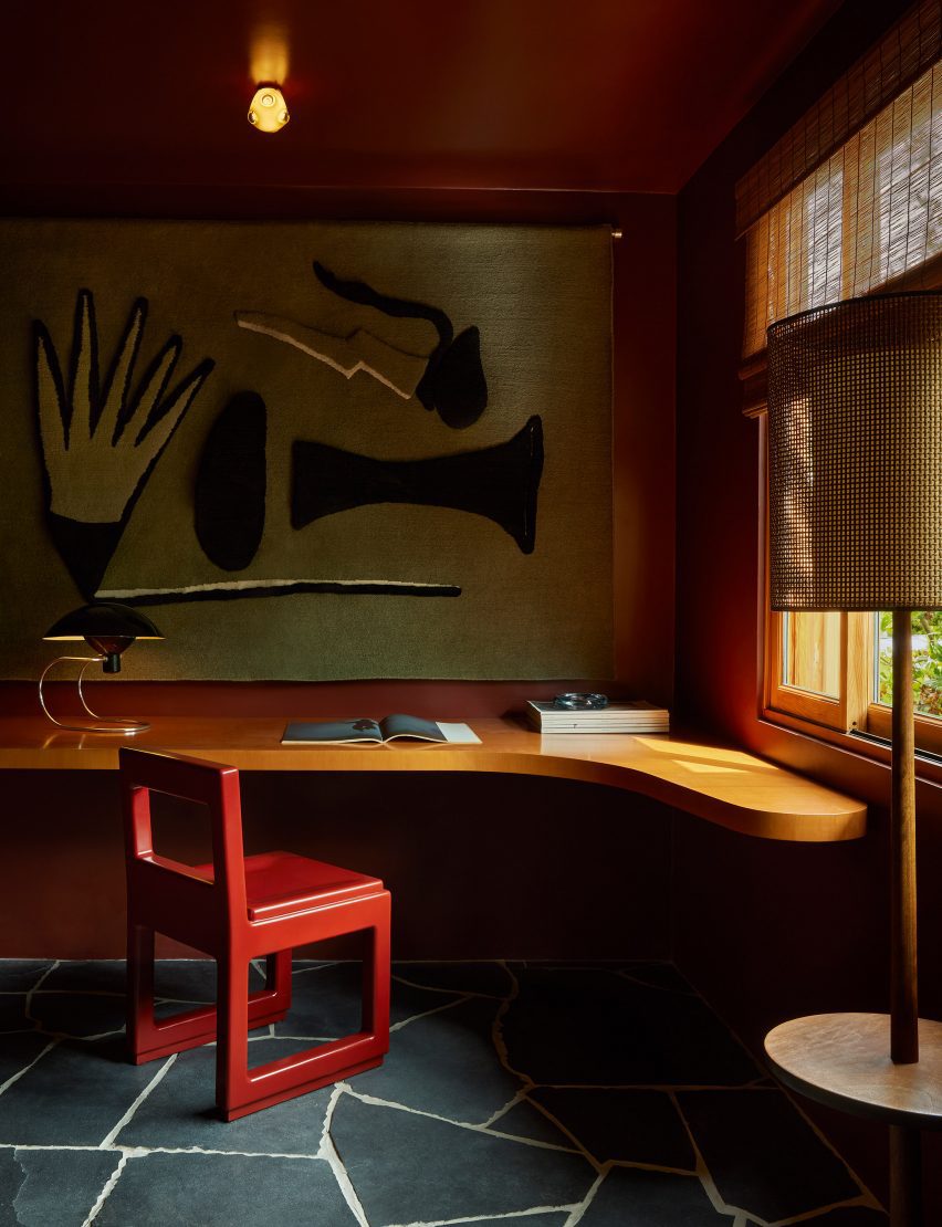 Study with black flagstone flooring and a bright red chair