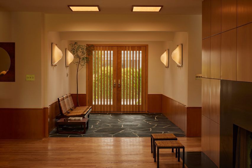Entryway with slatted from doors and black flagstone flooring