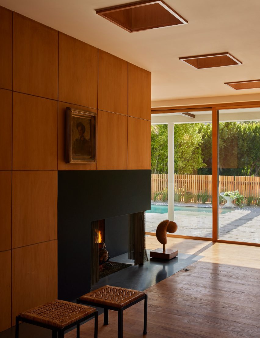 Living area with a black custom fireplace and a series of skylights 
