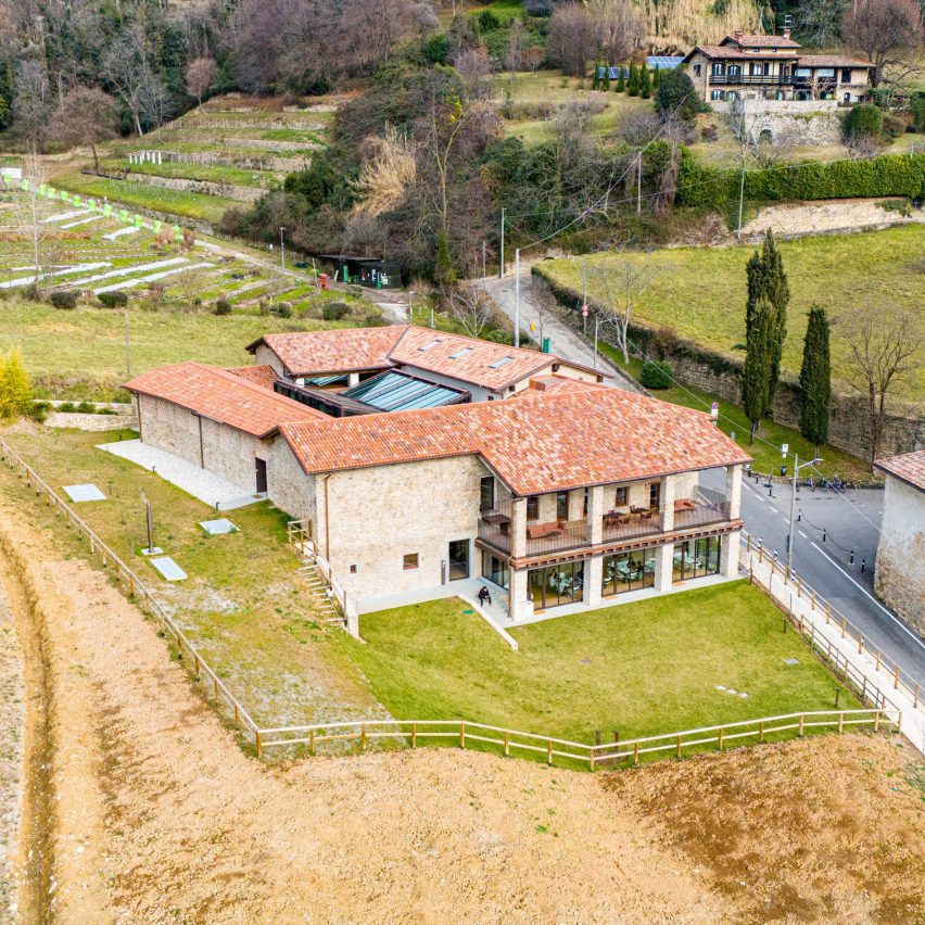 a photograph from above of a stone building in a green field