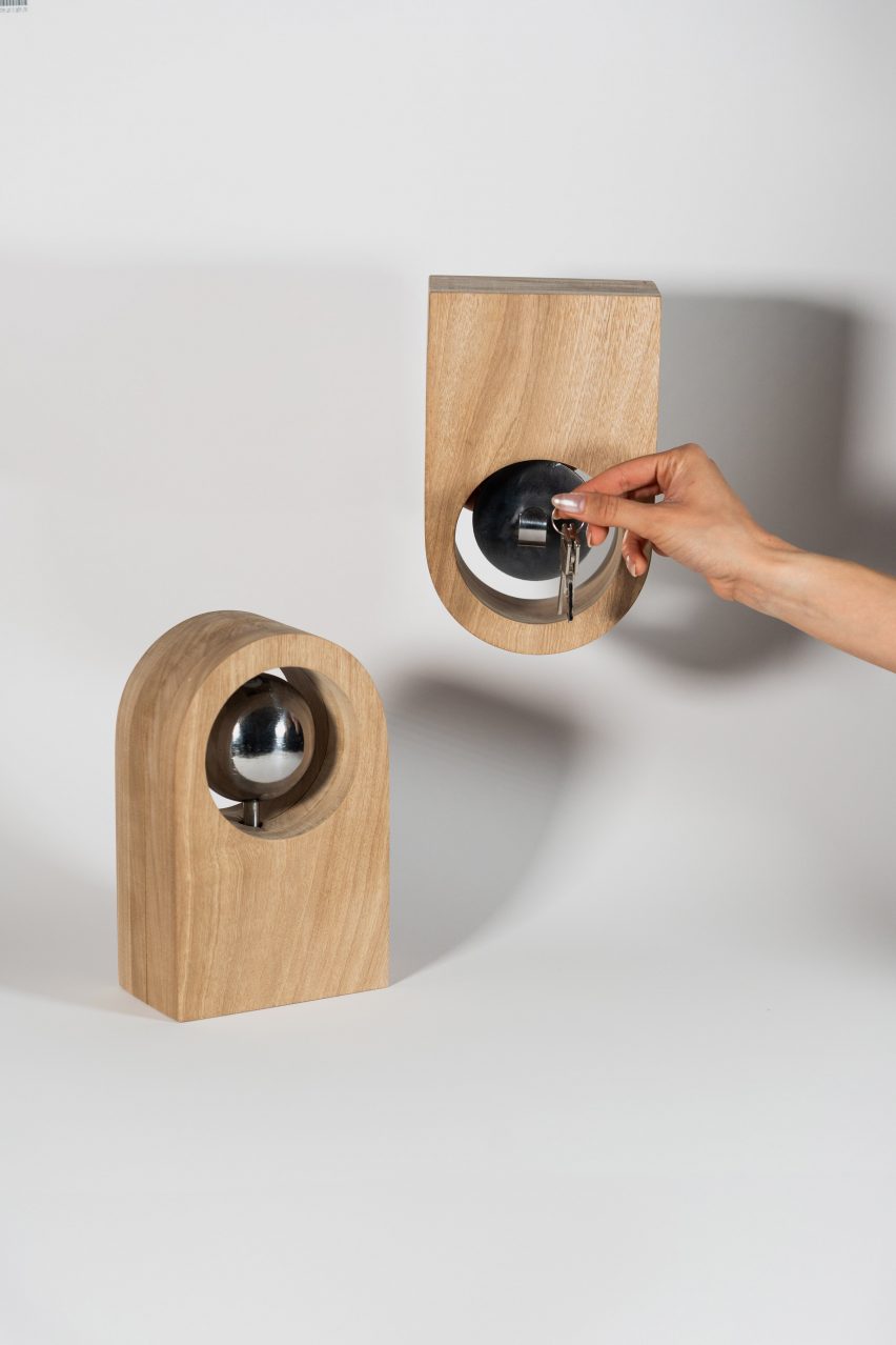 a photograph of two curved wooden objects, and a person's hand holding up a set of keys