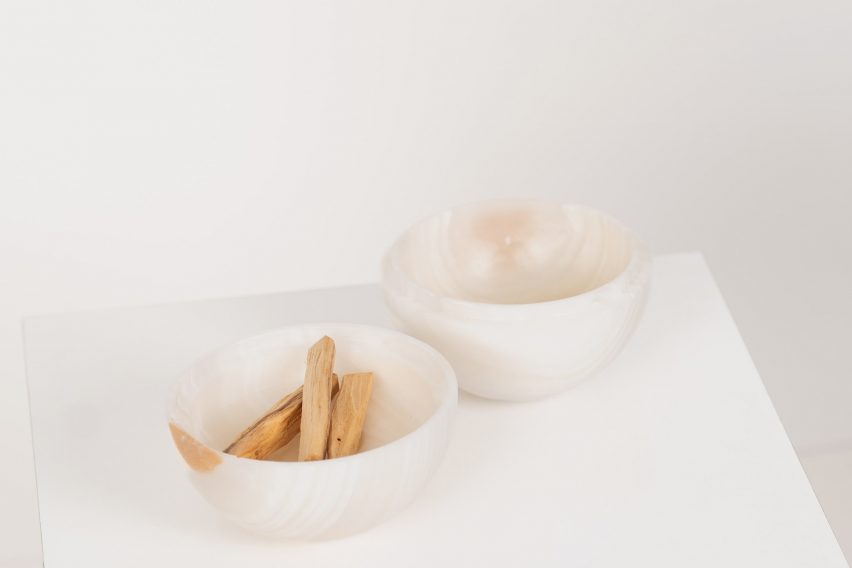 a photograph of two white bowls, one with wooden sticks in it