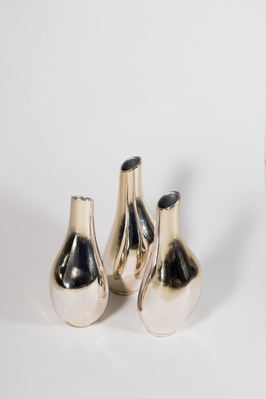 a photograph of three vases in metallic tones
