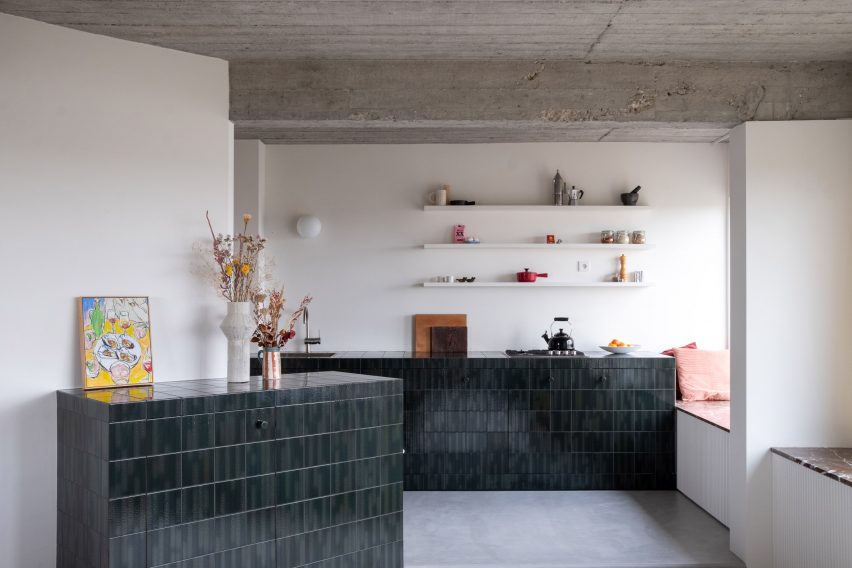 Kitchen clad in blue and green tiles