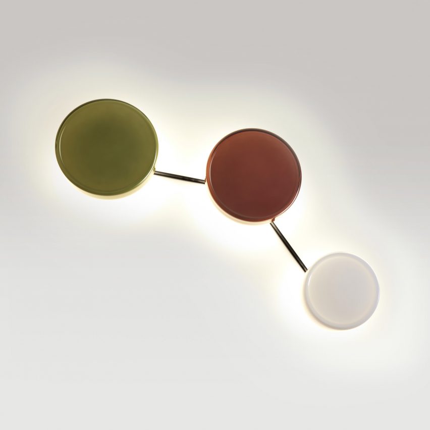 a photograph of three circular wall lights in tones of green, red and white