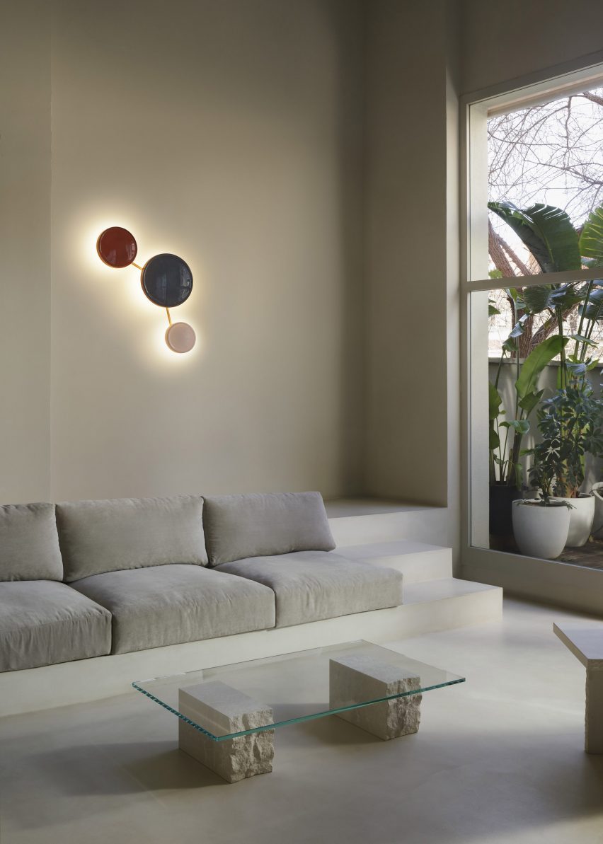 a photograph of three circular lights in tones of red, blue and white above a sofa