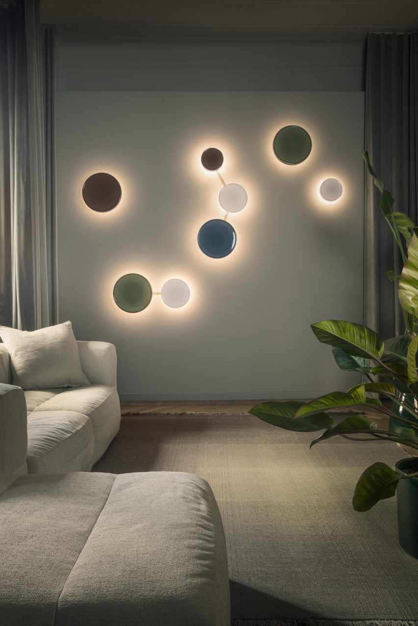 a photograph of circular coloured lights on a wall next to a sofa