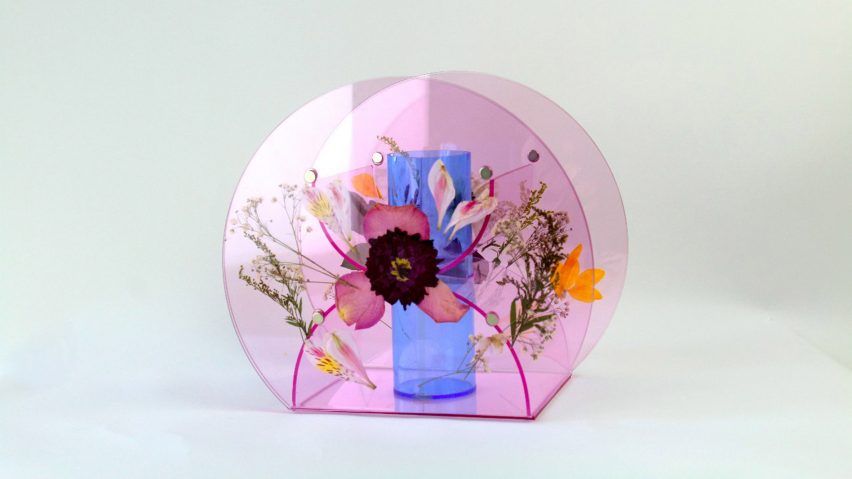 a photograph of a small vase in a circular form, in tones of pink and blue with floral patterns on it