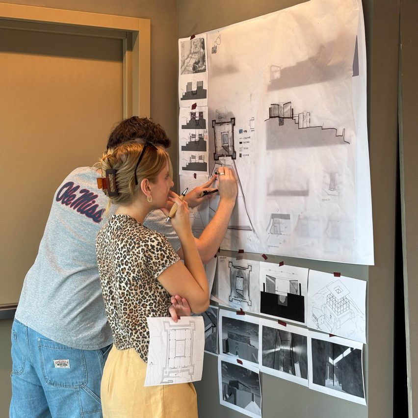 an image of students interacting with architecture work on a wall