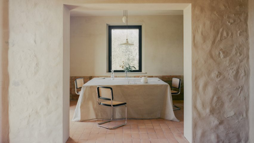 Cantilever chairs surrounding a tablecloth-draped dining table