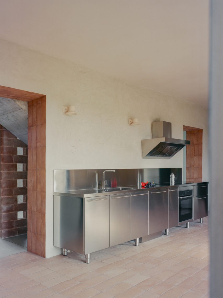 Stainless steel units in terracotta-floored kitchen