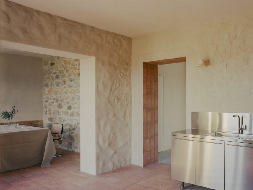 Rustic kitchen and dining room connected by a broad archway