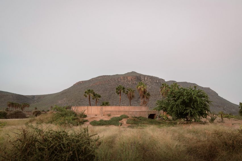 Half-buried concrete building within a desert landscape