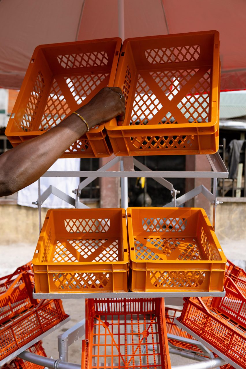 Man putting orange crates into a metal frame