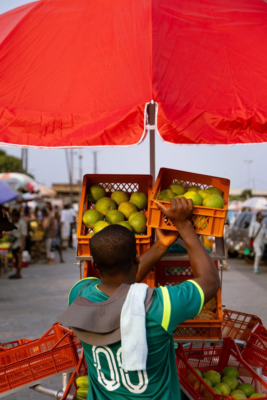 Man putting crate of fruit into a stall