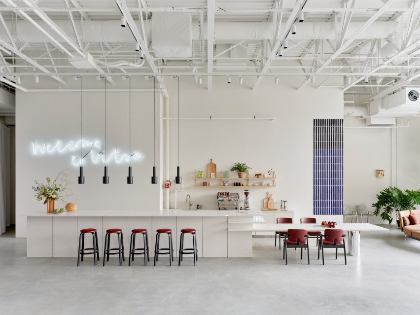 A communal bar and dining area with a light terrazzo counter