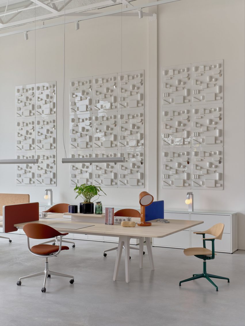 Wall-mounted relief panels of Dorothy Becker's Uten.Silo storage systems behind work stations