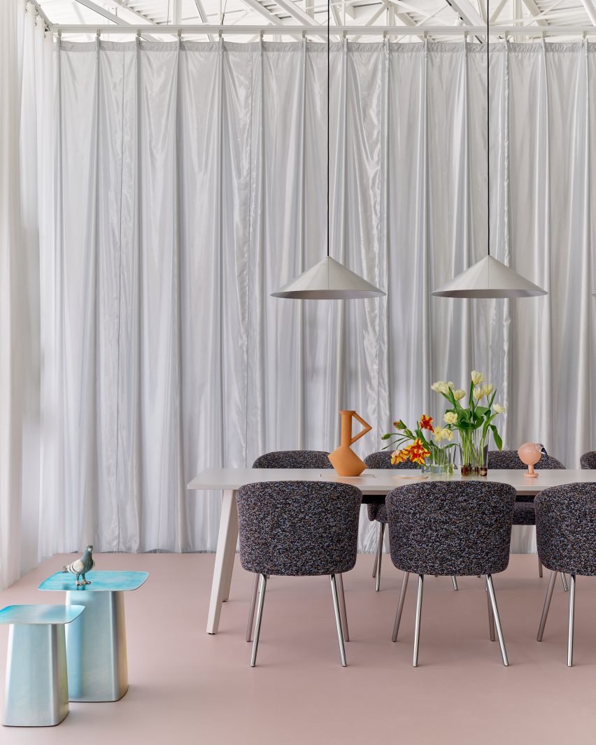 Dining table and chairs in front of a silver curtain