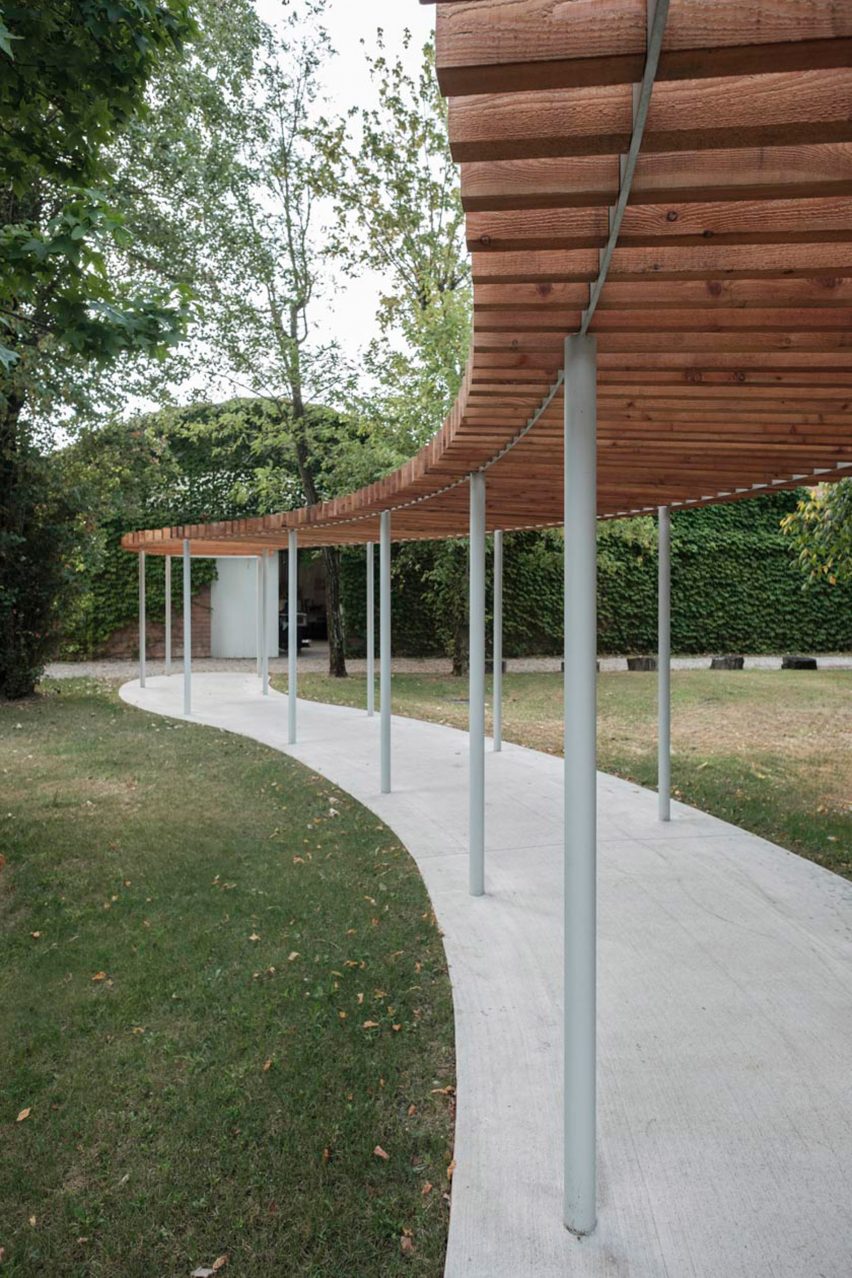 a visualisation of a pavilion in tones of grey and brown in a green garden