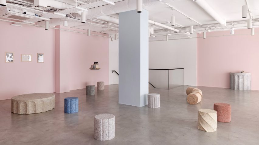 Photograph of an open-plan gallery exhibition showing various pieces of colourful granite-looking furniture such as stools, tables and benches.