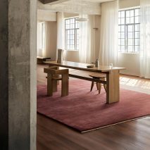 Photo of a room with a wooden table and chairs, and a pink rug, by Armadillo
