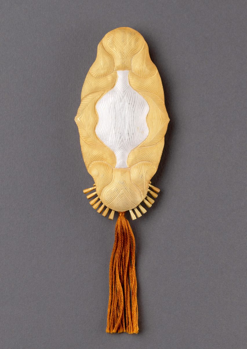 Photo of gold brooch with bronze coloured thread